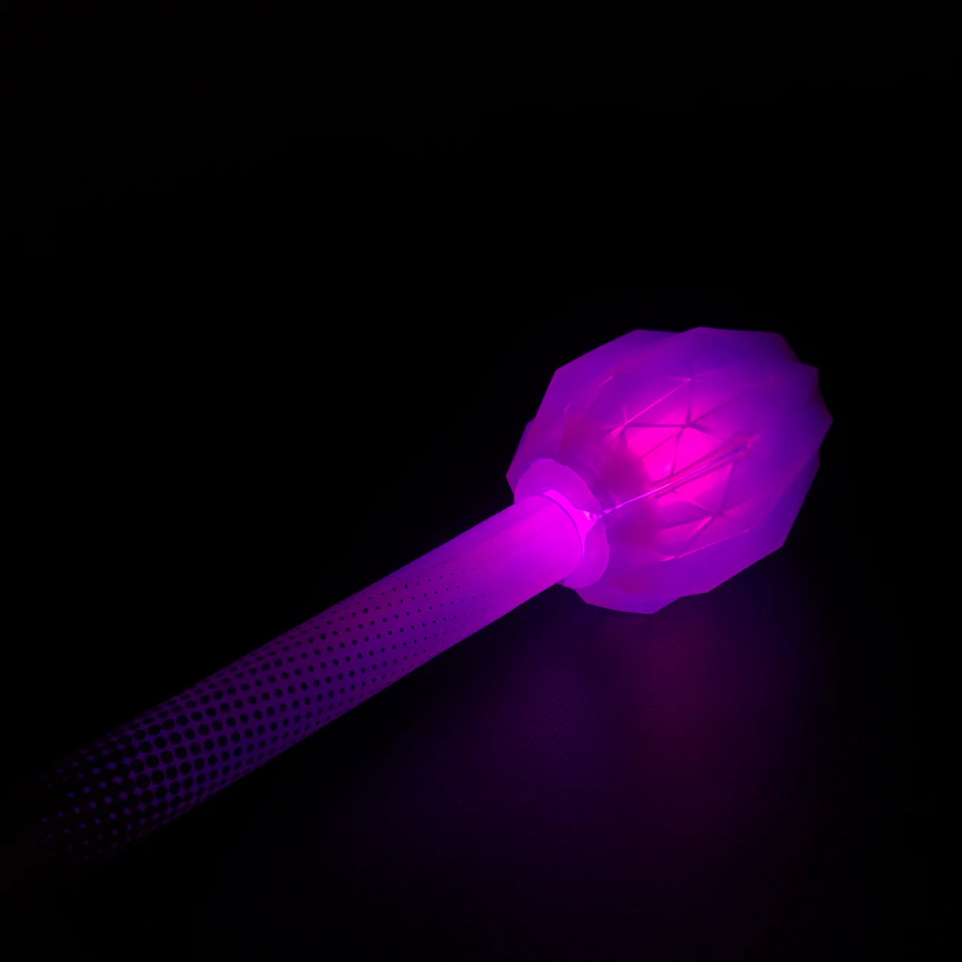Closeup of lit up led fusion prism end piece collapsible staff in a dark room