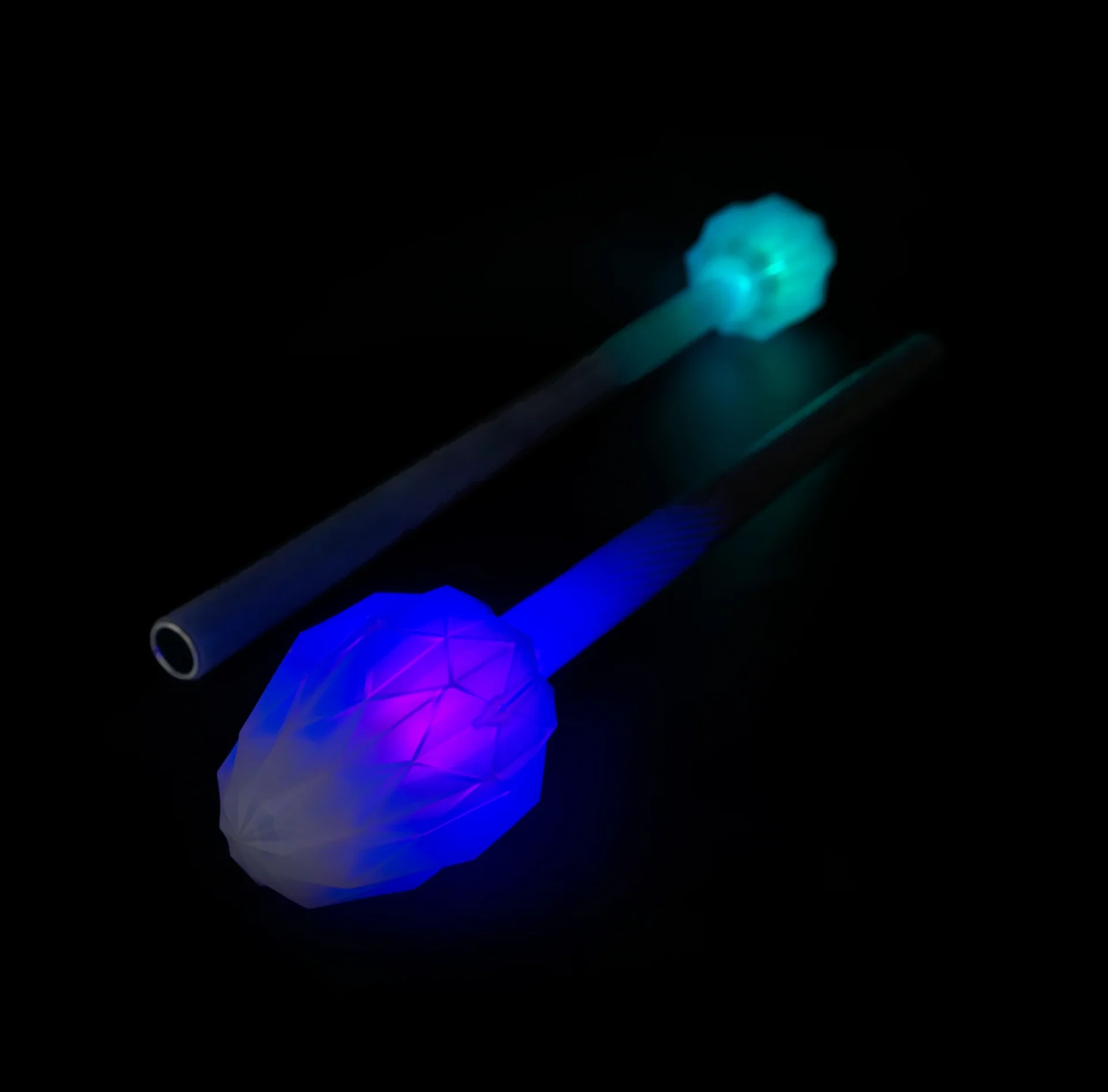 Closeup of lit up led fusion prism 3 piece collapsible staff in a dark room