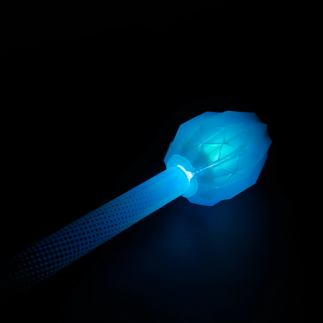 Closeup of lit up led fusion prism end piece collapsible staff in a dark room