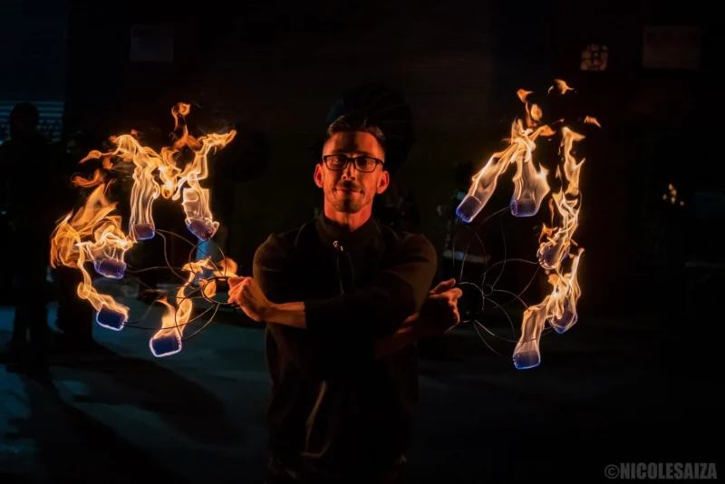 action shot of fire performer with fire dance fans