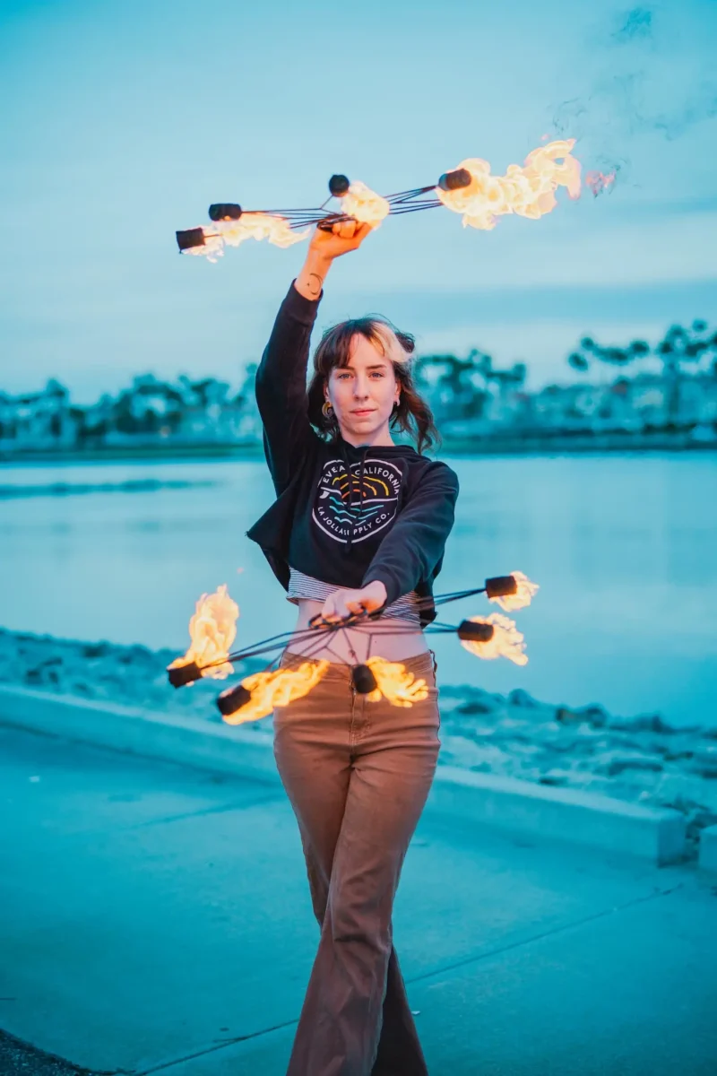 action shot of fire performer using a pair of fire fans