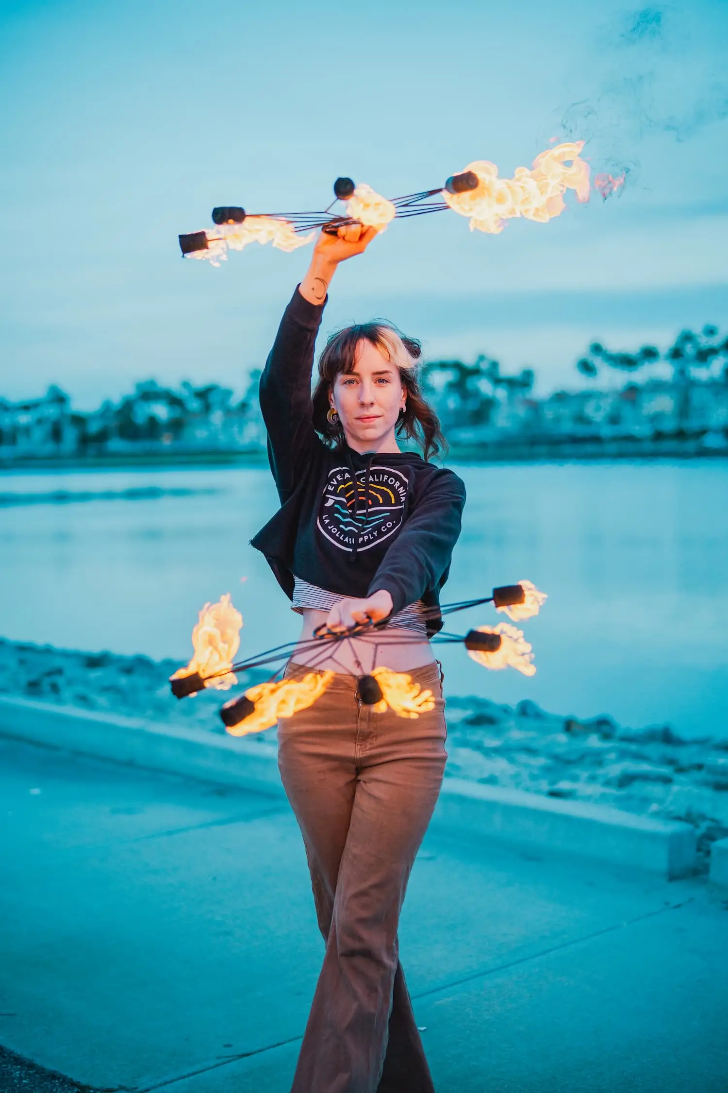 action shot of fire performer using a pair of fire fans