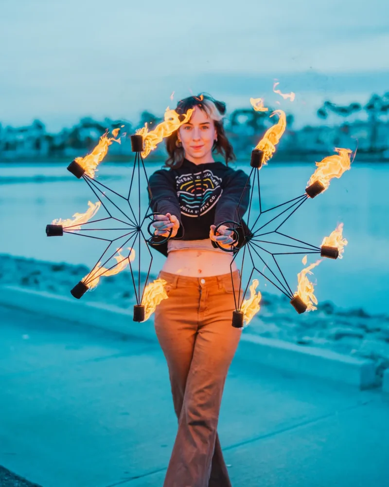 action shot of fire performer using a pair of fire fans