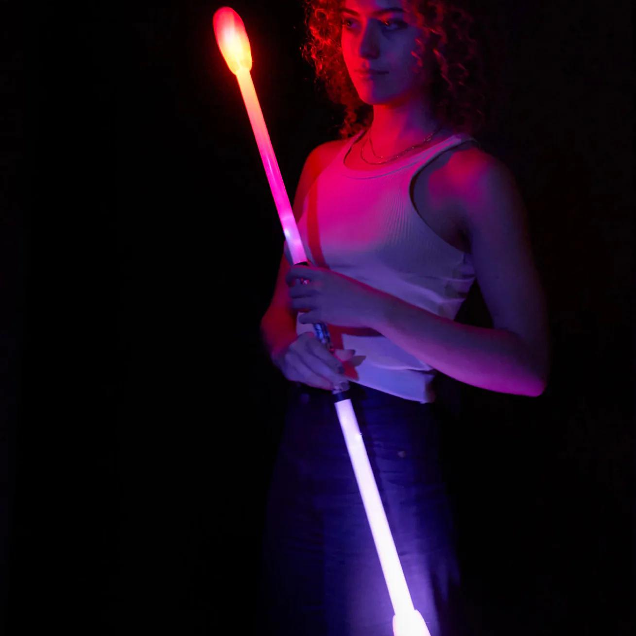 woman holding a lit led staff that is assembled