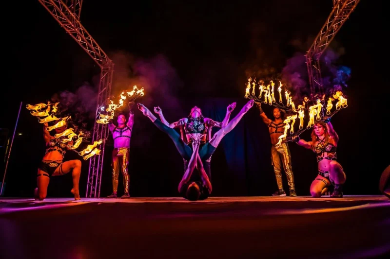 action shot of fire fans being used on a stage with acrobats