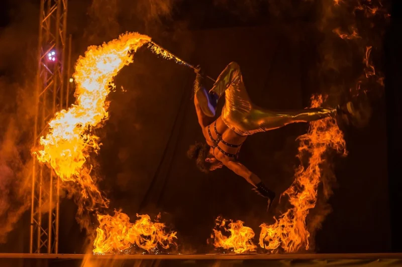 Action shot of performing using fire sword with lycopodium powder