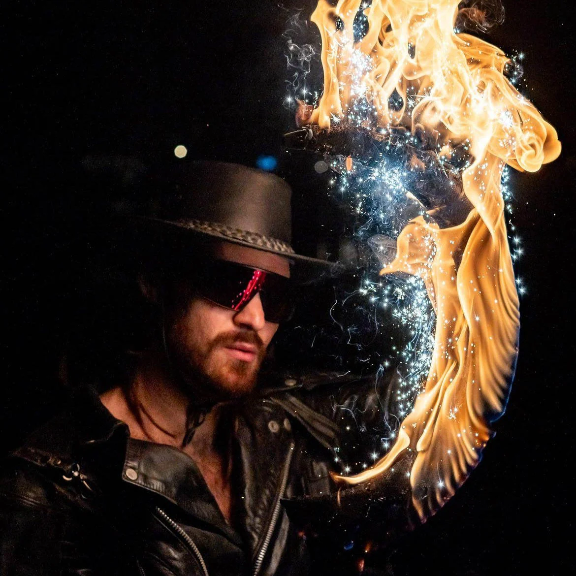 Closeup face shot of flowchucker with fire scythe using flow sparks