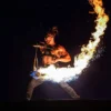 Action shot of flowchucker fire dancing with meteor chucks using flow sparks