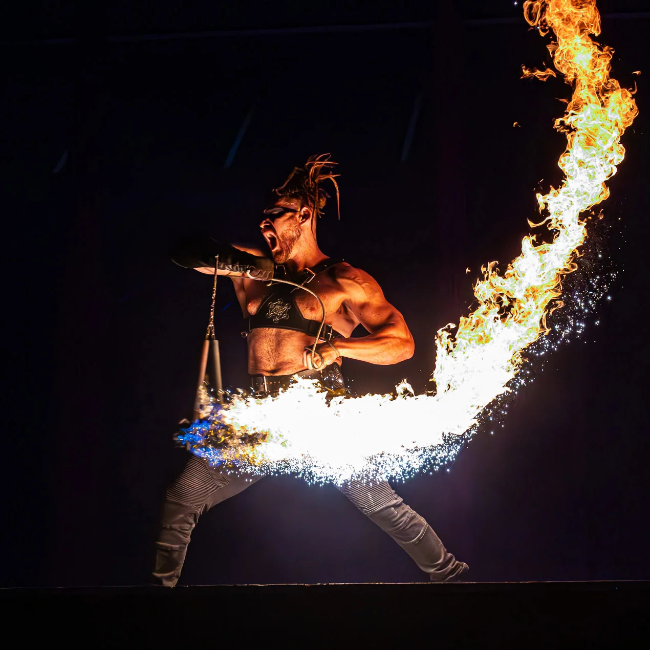 Action shot of flowchucker fire dancing with meteor chucks using flow sparks