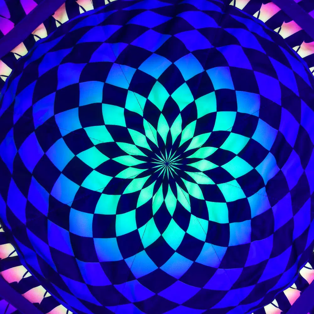 closeup shot of flow star under uv light with checkerboard mandala design