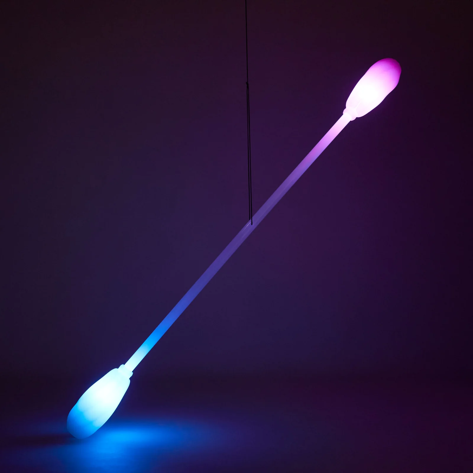 Leviwand being held up by it's string in a dark room