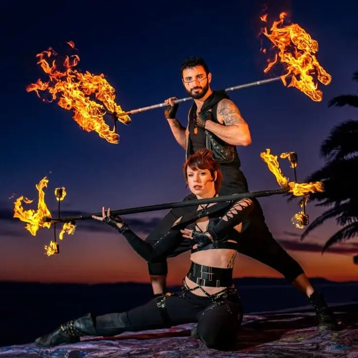 action shot of fire performers holding fire dragon staffs